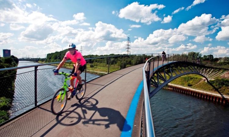 Cyclist crossing modern bridge